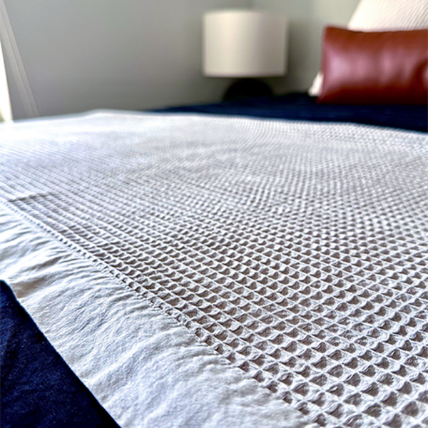 Stevens & Olivier Oversized Olivier Waffle Blanket spread over a bed as a throw blanket