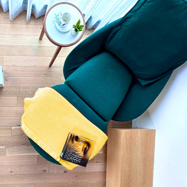 Folded oversized Olivier Waffle Blanket on side table in Lucky Yellow